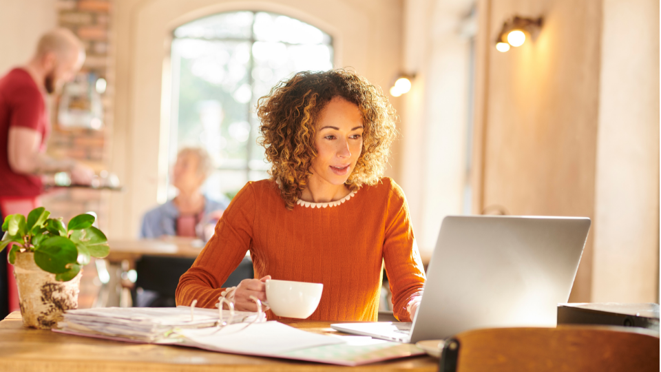 A professional woman working from a coffee place with her computer