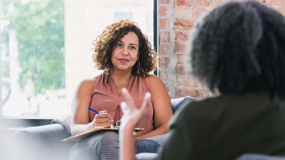 Two professional women having a workplace therapy session.