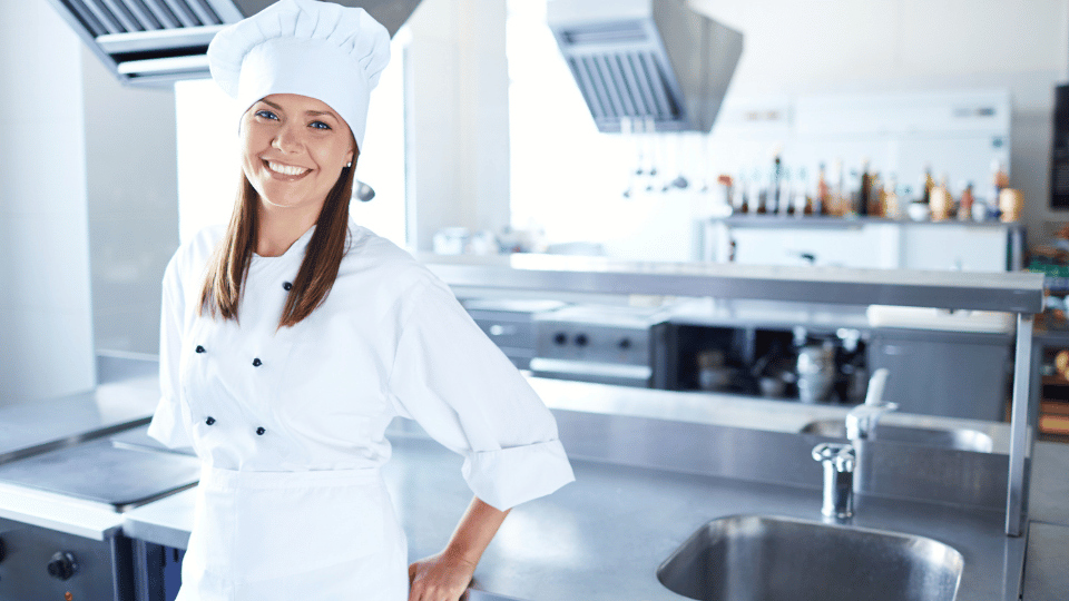 Una mujer chef empresaria con una sonrisa en la cocina