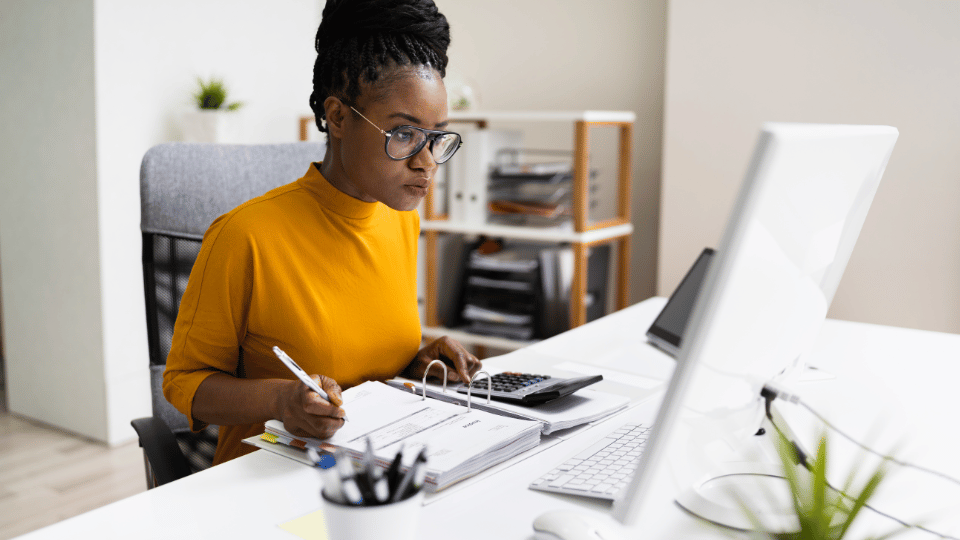 A woman business owner reading the requirements to qualify for a business loan