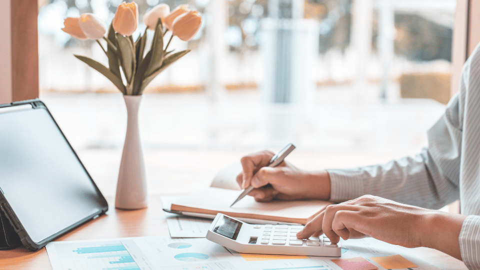 Una mujer emprendedora haciendo cálculos financieros en su calculadora