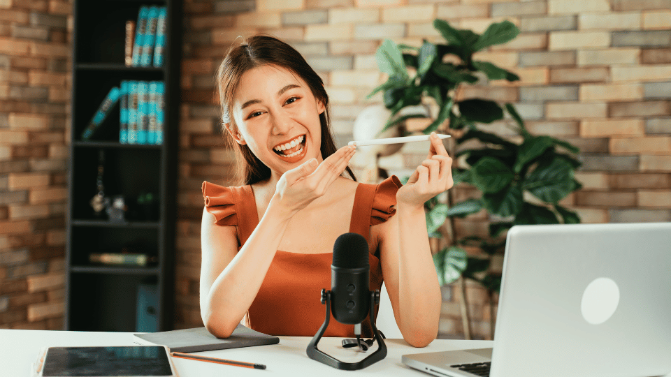 Una dueña de negocio sonriendo, tomando fotos y vendiendo sus productos