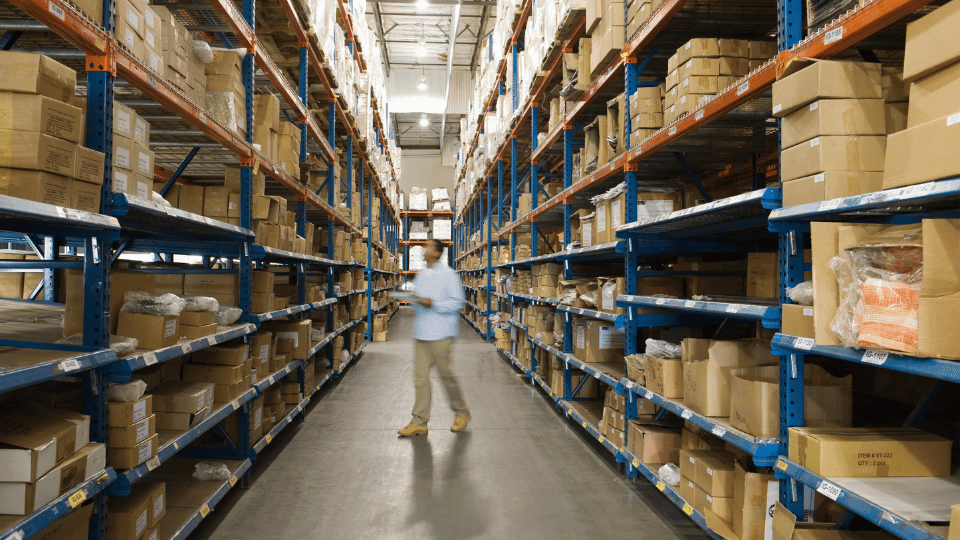 A man in a warehouse counting the inventory