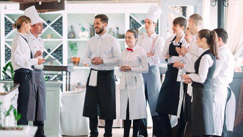 the staff of a restaurant gathered in the main room of the restaurant