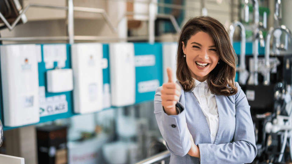A confident businesswoman giving a thumbs-up in a store, symbolizing the success and positive impact of SBA credit lines on small businesses.