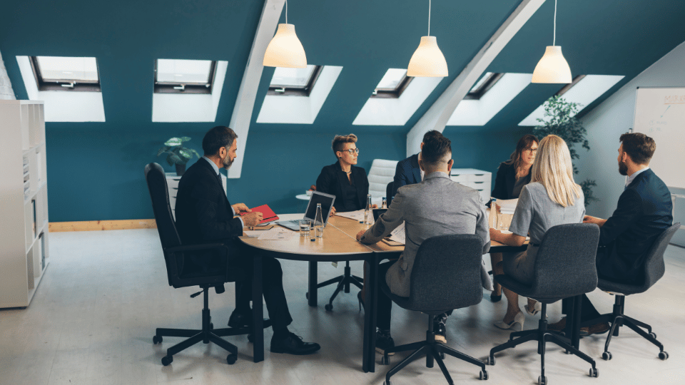 A group of professionals having a meeting in a modern office setting, representing the collaborative and structured nature of a corporation.